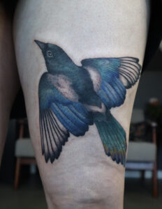 Magpie tattoo in vintage style on thigh
